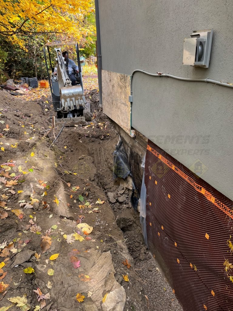 Basement waterproofing project in Etobicoke, Toronto, showing excavation, foundation coating, and membrane installation for water protection.