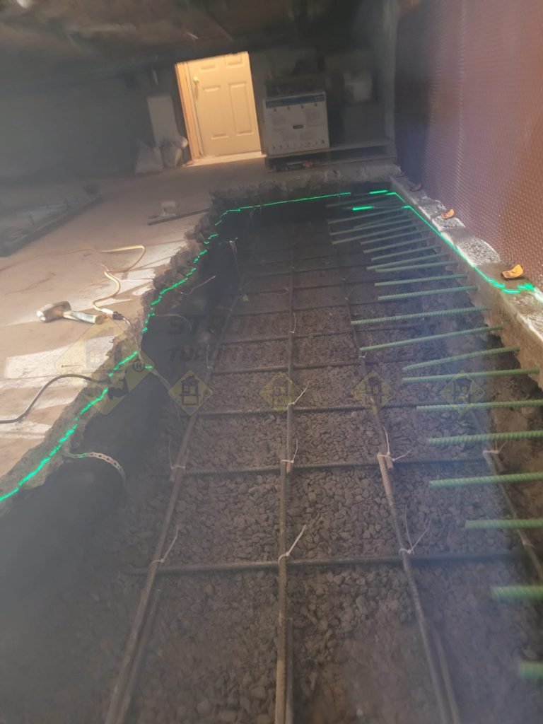 Basement underpinning in Newmarket, Ontario, with steel rebars installed for foundation reinforcement before concrete pouring.