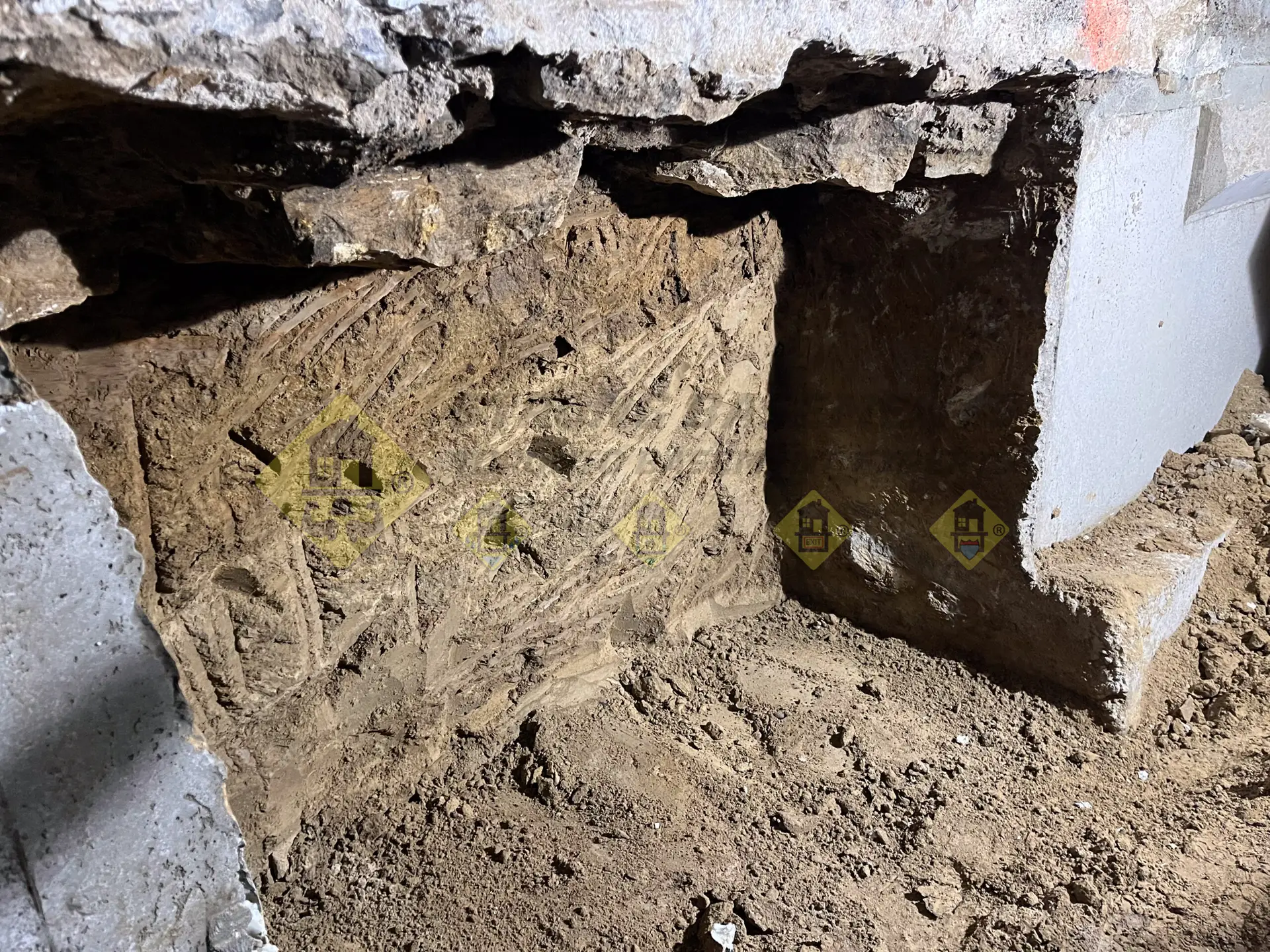 The final excavated underpinning section located between two newly poured L-shaped concrete foundation walls during a basement lowering project in Leaside, Toronto.
