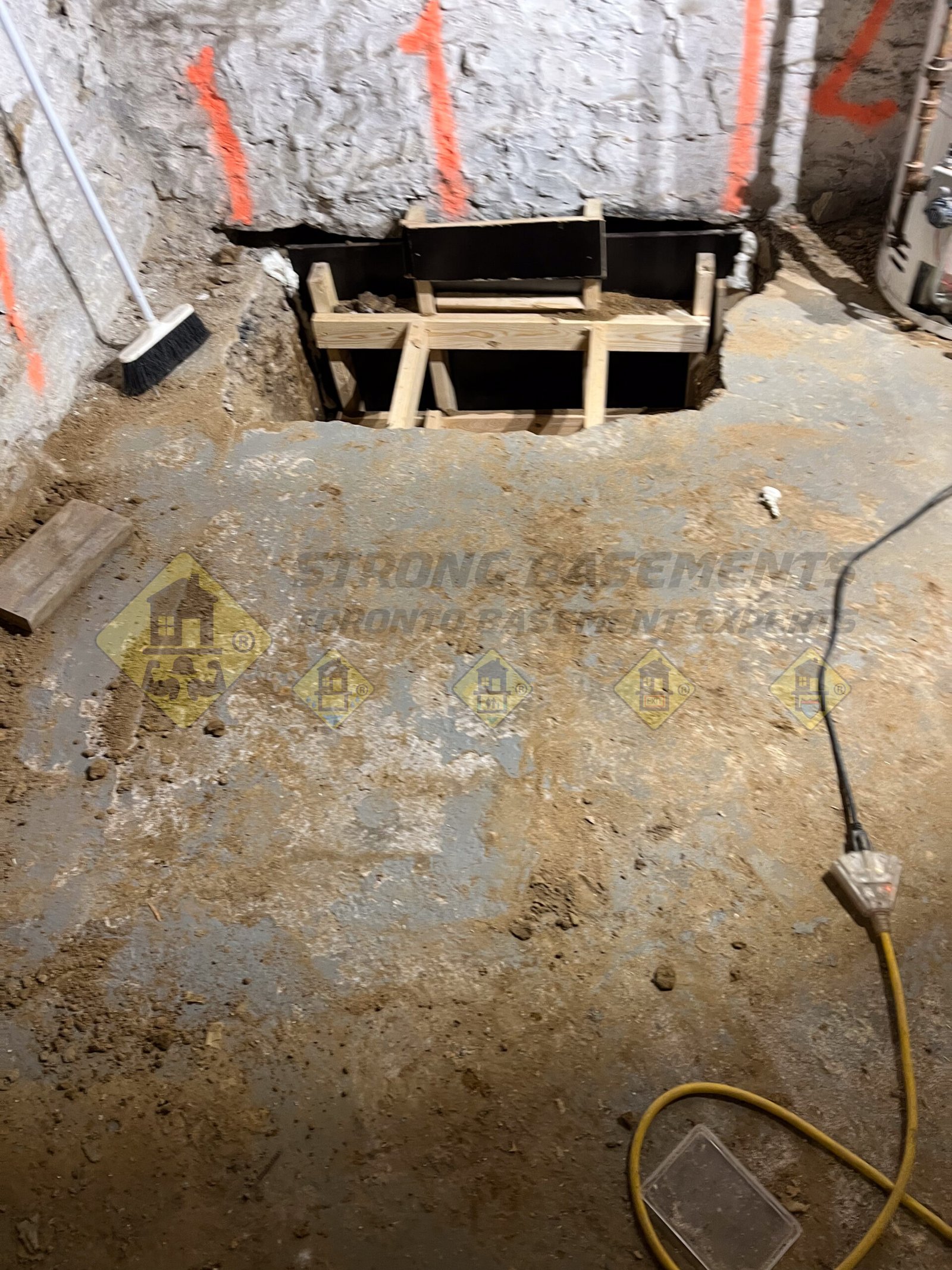 Excavated underpinning section N1 with a custom L-shape concrete form installed flush with the wall during a basement lowering project in Leaside, Toronto.
