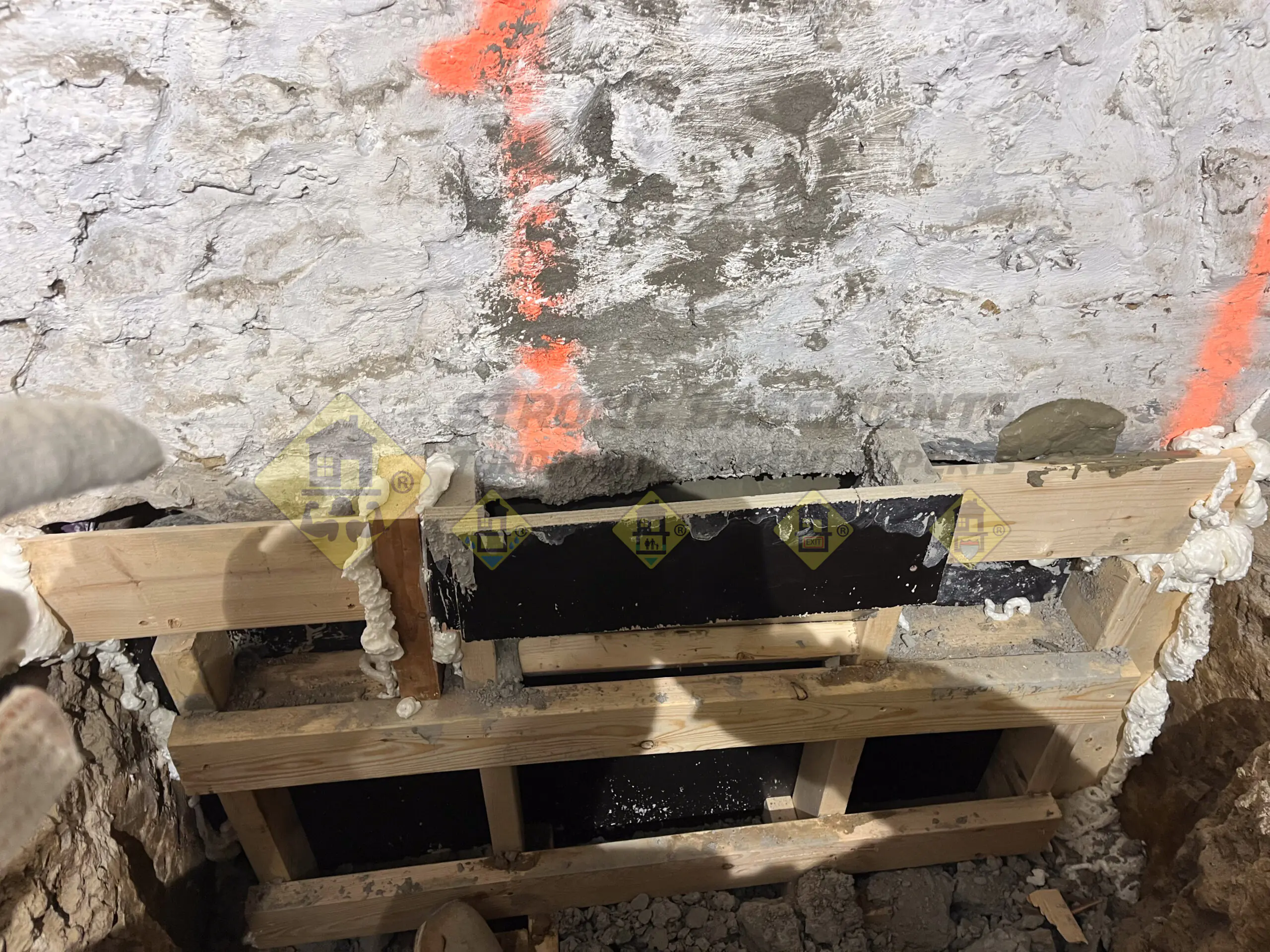 Fresh concrete poured inside a custom L-shaped concrete form installed over an excavated underpinning section during a basement lowering project in Leaside, Toronto.