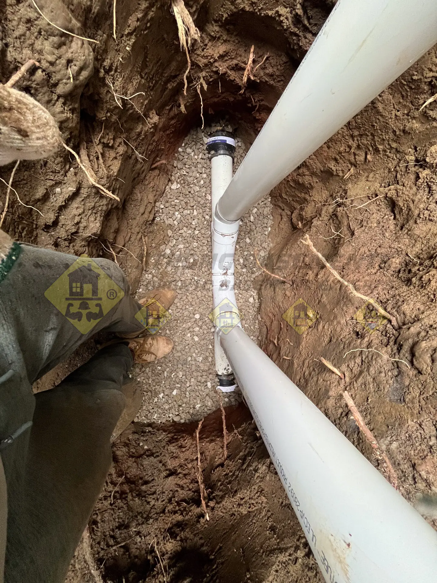 A 7-foot deep excavated hole showing a new 4-inch PVC pipe and two back-to-back cleanouts successfully replacing an old clay building trap in Leaside, Toronto.
