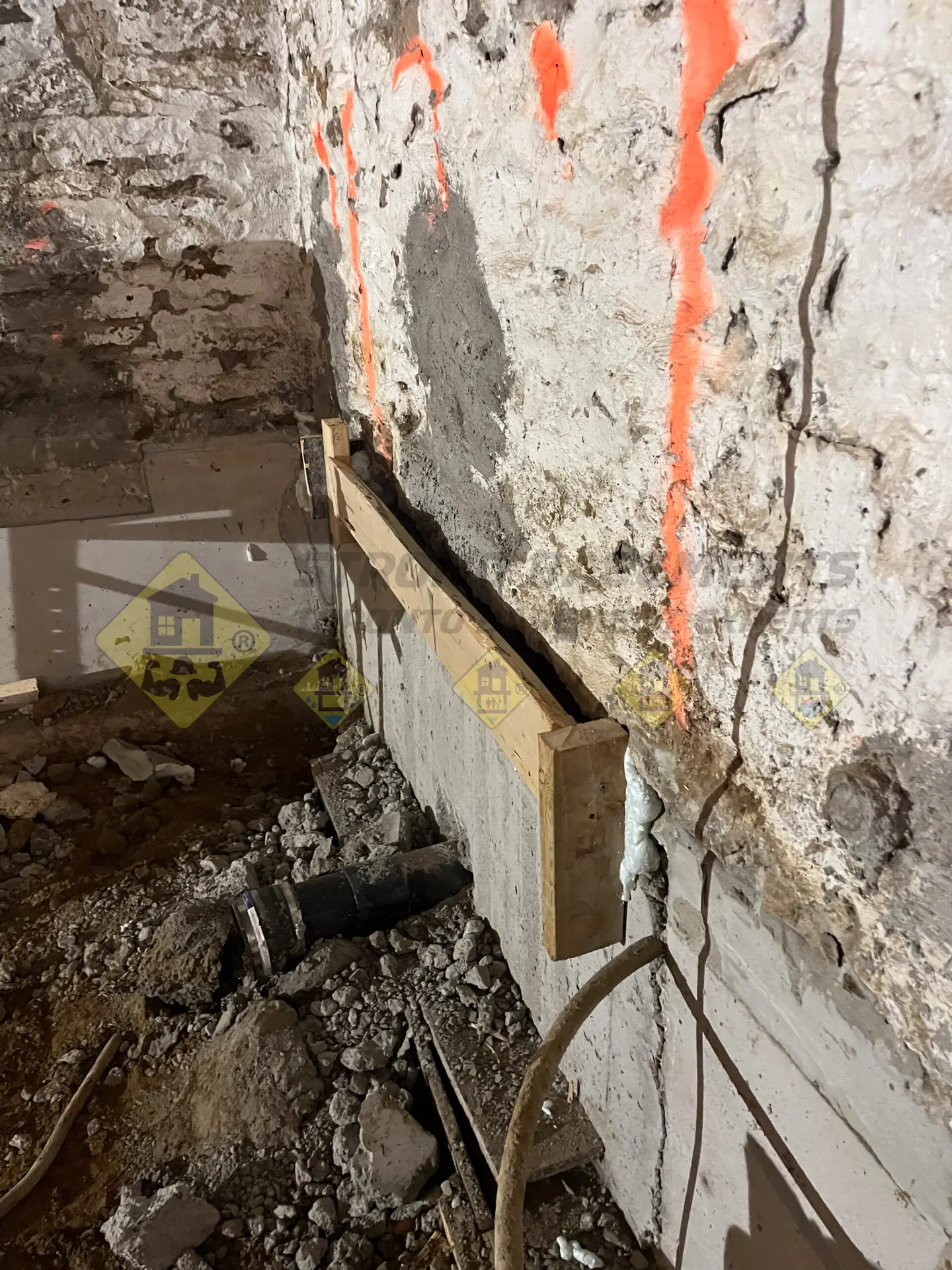 Custom wood forms sealed with foam to create a watertight well on top of a concrete underpinning section, prepared for a liquid non-shrink grout pour beneath an old stone foundation in Leaside, Toronto.
